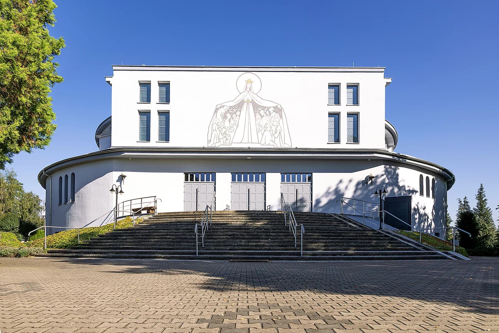 Fasada kościoła NMP Królowej Świata w Rogach ze schodami przed wejściem