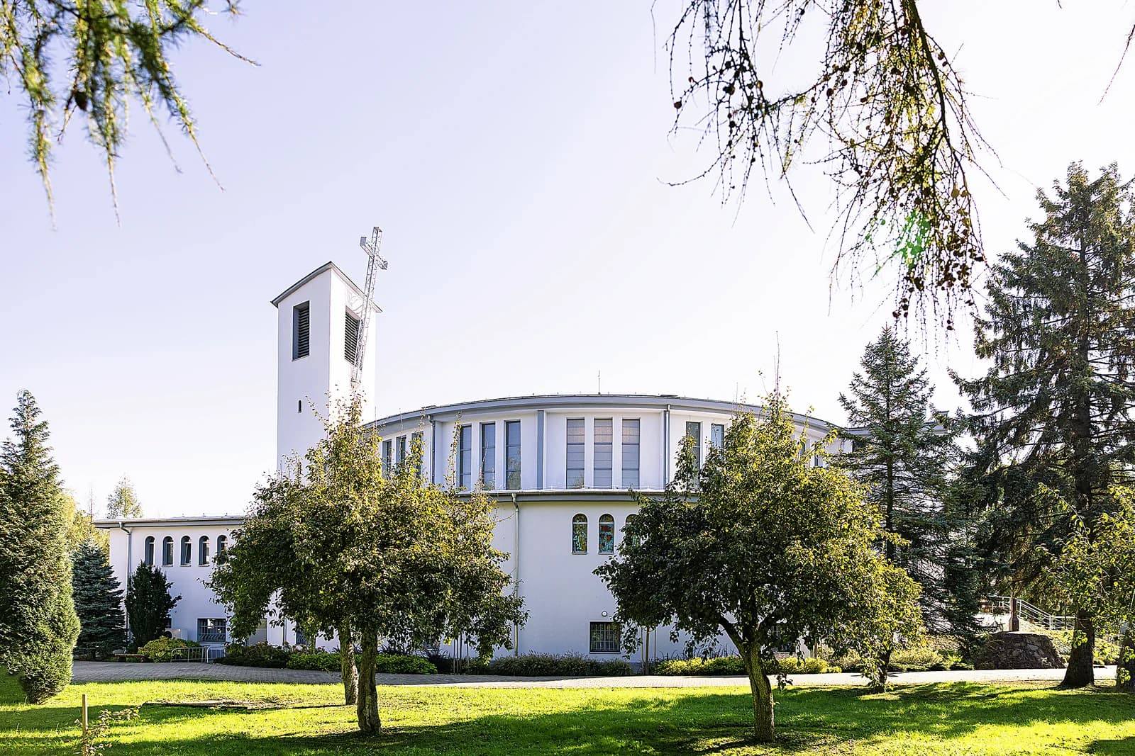 Kościół-rotunda NMP Królowej Świata w Rogach w pełnym profilu, otoczony drzewami