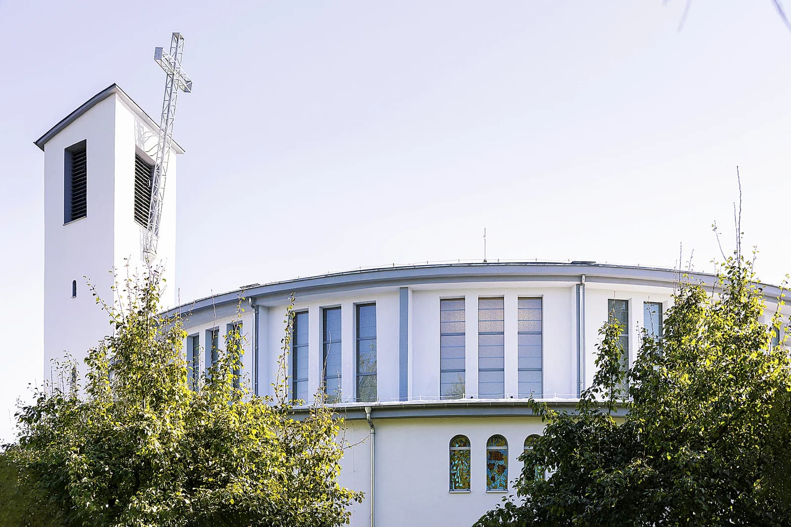 Wieża i bryła kościoła NMP Królowej Świata w Rogach wśród drzew